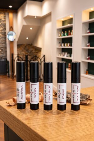 Cinq échantillons 2 ml Rose&Oud boisés posés sur le comptoir de la boutique : Gold’N’Wood, Sicario, Venice Beach, Kosmos, Cœur de Pirate
