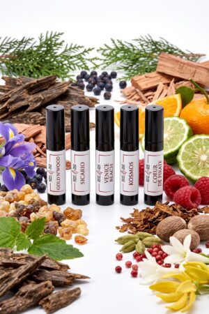 Coffret Découverte — Boisés & Caractère (5 × 2 ml) : échantillons 2 ml Rose&Oud entourés des ingrédients de leurs parfums, sur fond blanc